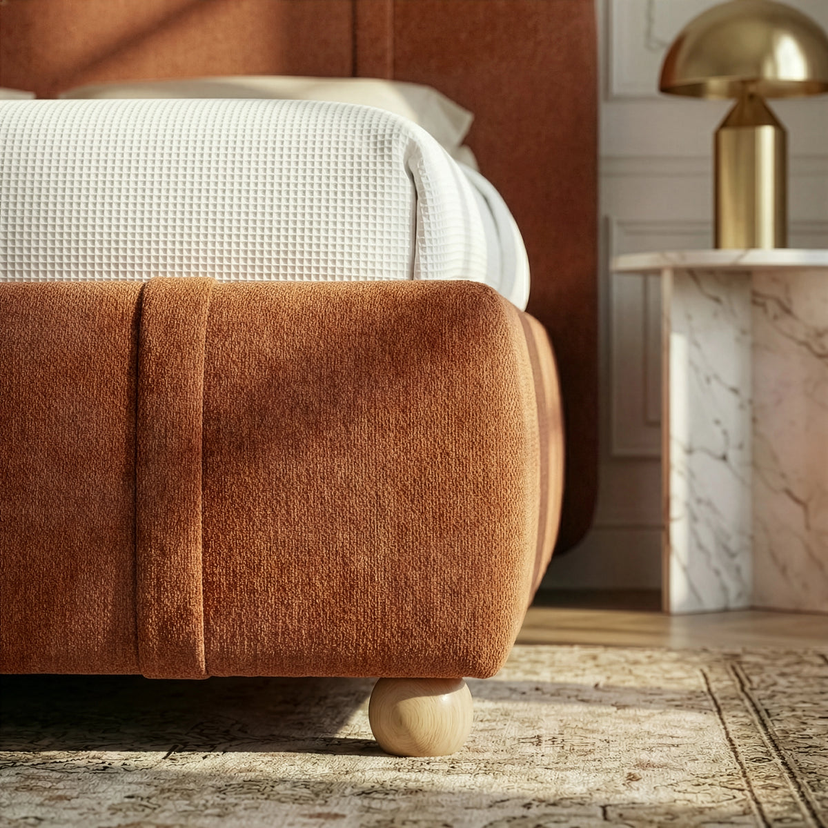 [Double | Orange] Close-up of footboard corner showing rounded padded edge with wooden ball foot and vertical stitching