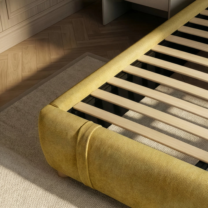 [Double | Yellow] Bed frame base showing wooden slats and rounded padded footboard corner from above