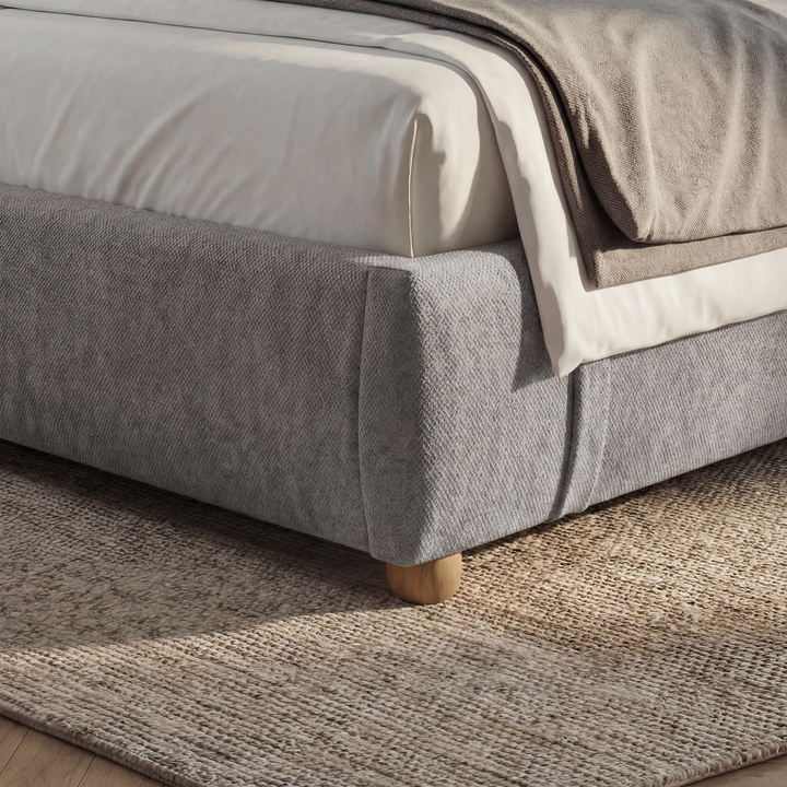 [King | Grey] Lower foot-end detail with soft upholstered corner and natural oak leg on herringbone floor