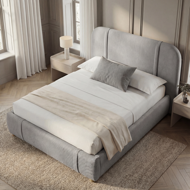 [King | Grey] Overhead angled view of Vynarae fabric bed frame with curved headboard and white bedding on jute rug