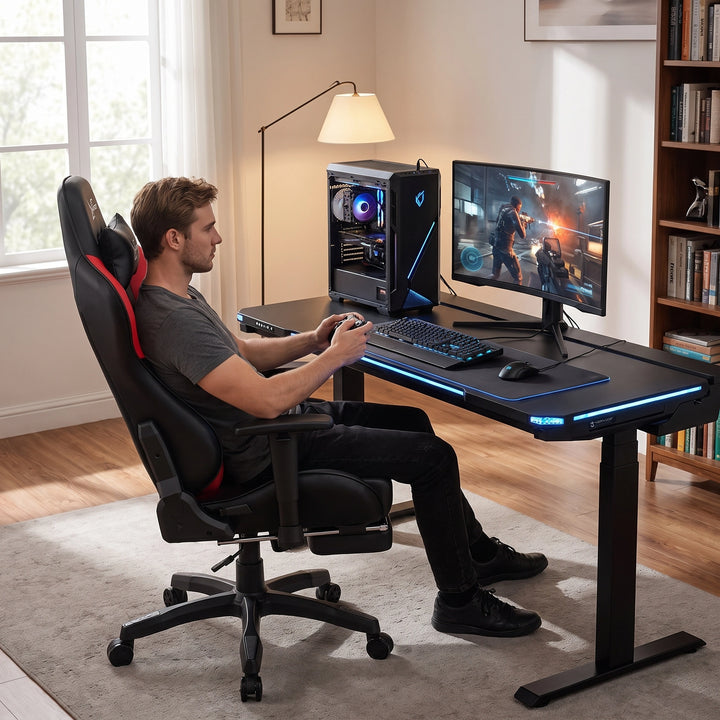 [Black + Red] A man sits on a gaming chair at a black adjustable desk with blue LED lighting, using a computer setup
