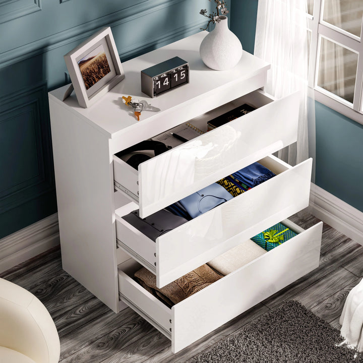 [Black] high gloss 3 drawer chest elevated view with all drawers extended showing headphones books and folded clothes
