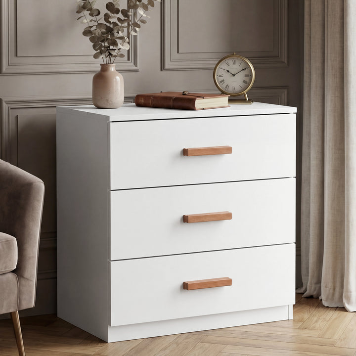 [White] three drawer chest placed in room beside window with clean lines and wooden horizontal handles