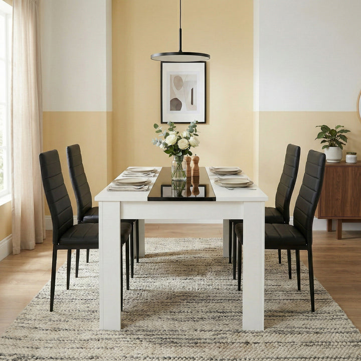 [4 Seater | Black] White & Black Gloss 4-6 Seater Dining Table with four black faux-leather chairs set for two in a bright yellow-toned dining room