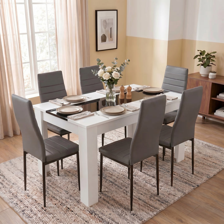 [6 Seater | Grey] White & Black Gloss 4-6 Seater Dining Table photographed from an angled front view with six grey chairs and full tableware in a bright dining space