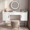 [White] dressing table with three drawers and a round mirror in flutrina design, placed against a wall in a softly lit room