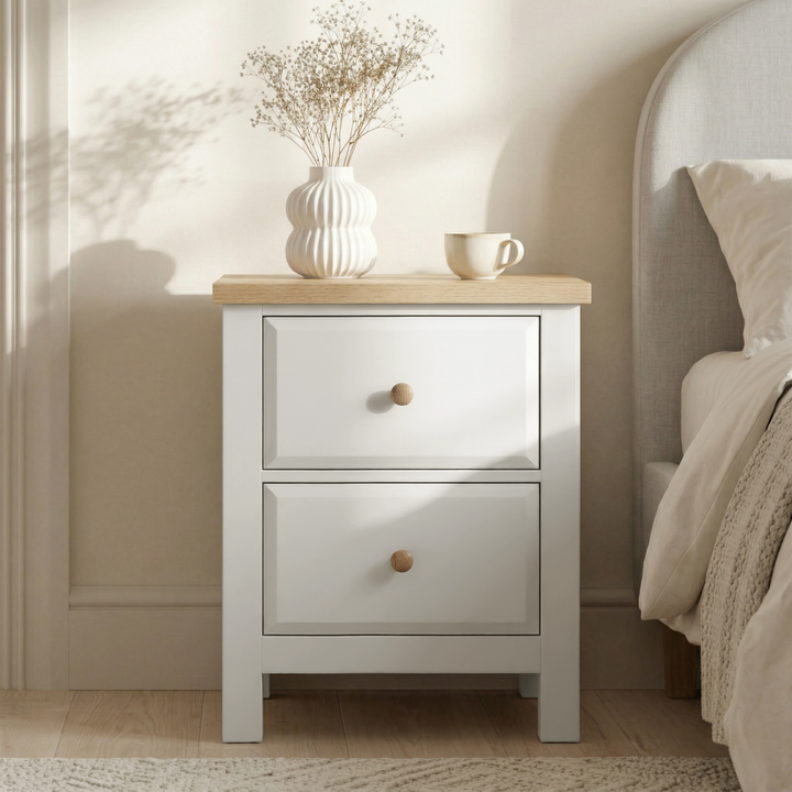 [White] Haven white nightstand with two drawers and oak top, ribbed vase and cup styled next to upholstered bed