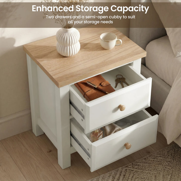[White] nightstand with oak veneer top and open drawers, featuring a cup and vase on top