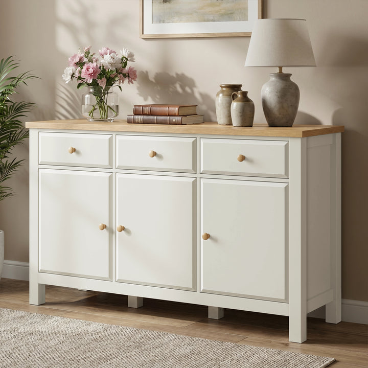 [White] Haven sideboard angled view showing oak top, framed doors, drawers, vases, books, and lamp.