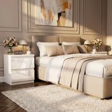 [White] Neatly made bed in a bedroom with decorative elements.