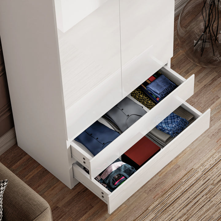 [White] two bottom drawers of white high gloss wardrobe pulled out showing folded clothes in vibrant colours