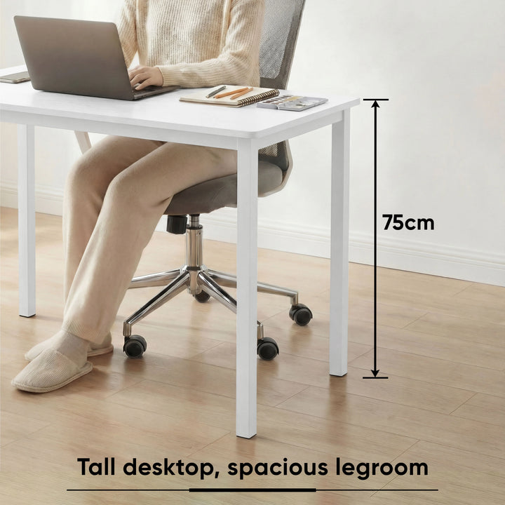 [120 x 50 cm] Home Office Desk shown with woman working on laptop, highlighting 75cm tall desktop height and spacious legroom for comfortable seating