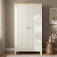 [White] 2 Door wardrobe with oak wood top and in a room with a plant and vase on a small table