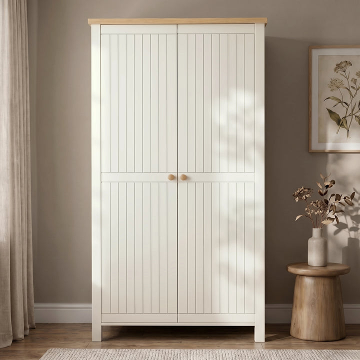 [White] 2 Door wardrobe with oak wood top and in a room with a plant and vase on a small table