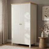 [White] 2 door wardrobe with wooden top and legs in a room with a plant and vase on a small table