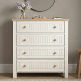 [White] Linra White Painted 4 Piece Bedroom Set four-drawer chest front view with tongue-and-groove fronts, paired round wooden knobs, oak top, and lilac flowers beside a round mirror