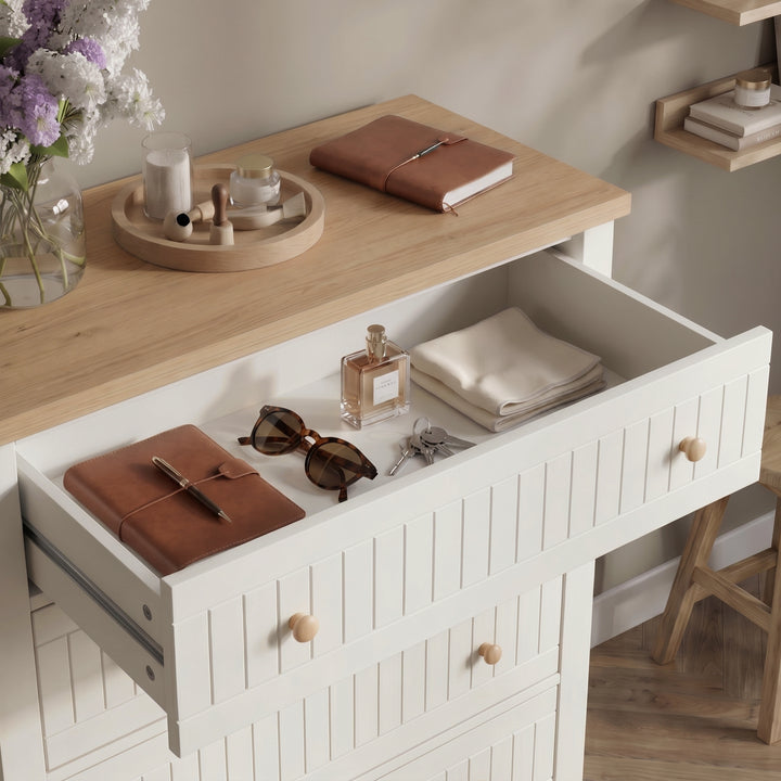 [White] Linra tall 5 drawer chest with all five drawers open at an angle showing stored folded clothing and accessories against wall