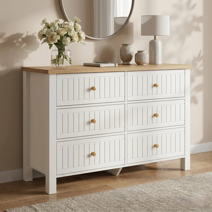 [White] Linra large 6 drawer chest angled view in green room with oak top, lamp on left and vase on right