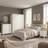 [White] Linra White Painted 4 Piece Bedroom Set styled in a bright bedroom with a double bed, large windows, botanical wall prints, and neutral linen bedding on a jute rug