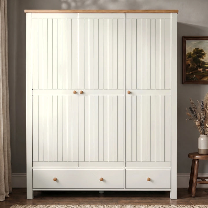 [White] Linra White Painted 4 Piece Bedroom Set triple wardrobe shown front-on with tongue-and-groove doors, oak top, round wooden knobs, and two base drawers
