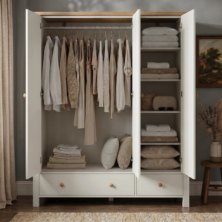 [White] Linra White Painted 4 Piece Bedroom Set triple wardrobe open showing full-width hanging rail with clothes, shelved compartment with folded linens, and base drawers