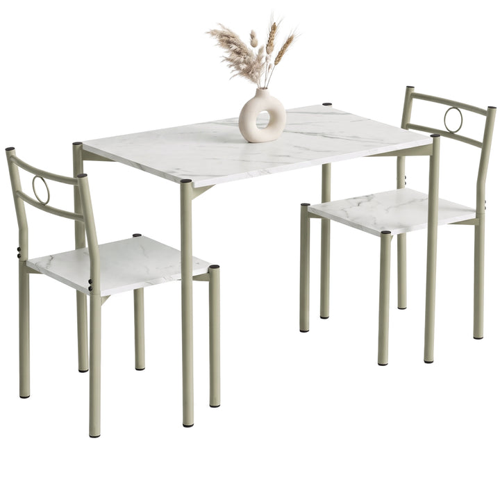 [White Marble] Angled studio view of the three-piece dining set with two chairs, circular backs, pale frames and a decorative vase