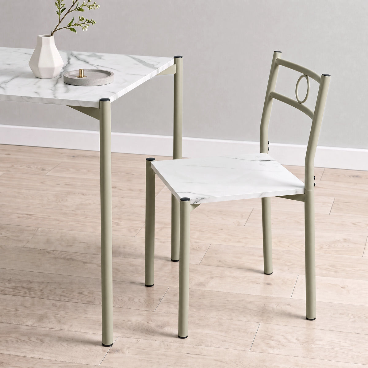[White Marble] Close-up showing the tabletop edge, chair seat, pale round-pipe legs, circular chair backs, tray and vase
