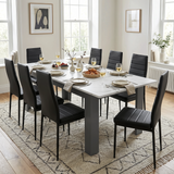 [White Marble] Extended marble-effect dining table for 6-8 at breakfast; eight black chairs surround its thick grey legs.