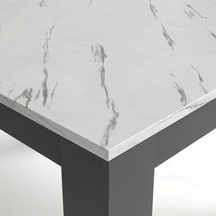 [White Marble] Close-up of the marble-effect tabletop corner and thick grey L-shaped leg; fine grey veining crosses the top.