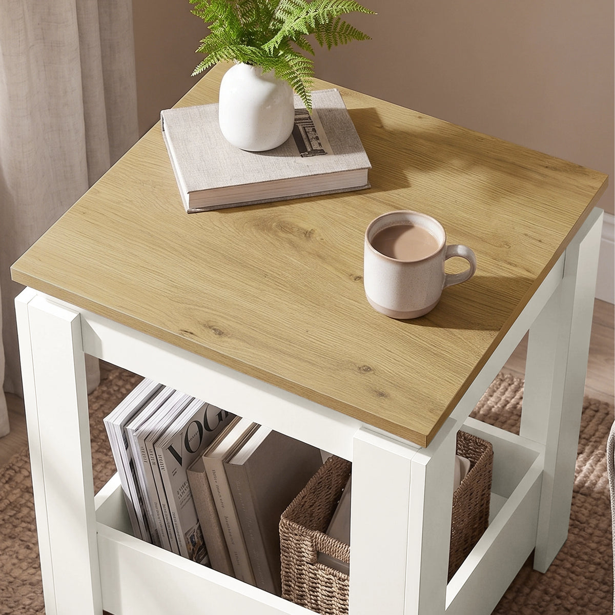 [White] High-angle view of the square side table top and open lower storage with books and a wicker basket