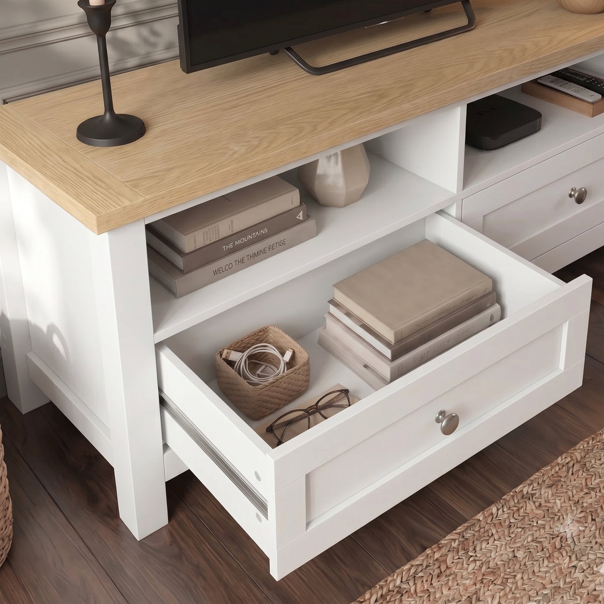 [White] Oskara White Painted TV Unit with Storage close-up with left drawer fully open on metal runners showing books, glasses