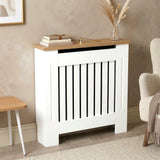 [Small | White] Radiator Cover Small oak top shelf close-up with books, a clock, and a vase styled on the surface with storage