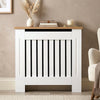 [Small | White] Radiator Cover Small with oak top shelf styled with dried grass, books, and a candle in a cosy living room