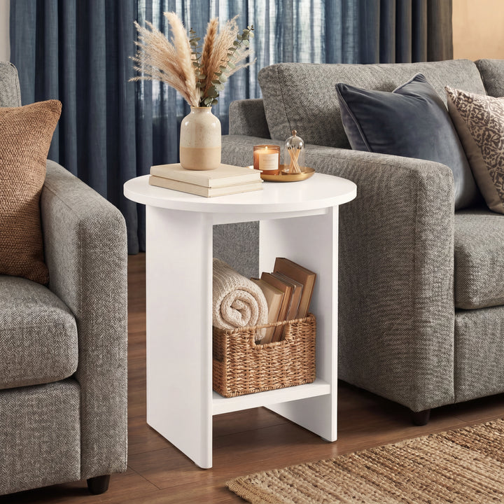[White] Small Round Side Table with Shelf Living Room positioned between two grey sofas with botanical vase on top and wicker basket on lower shelf