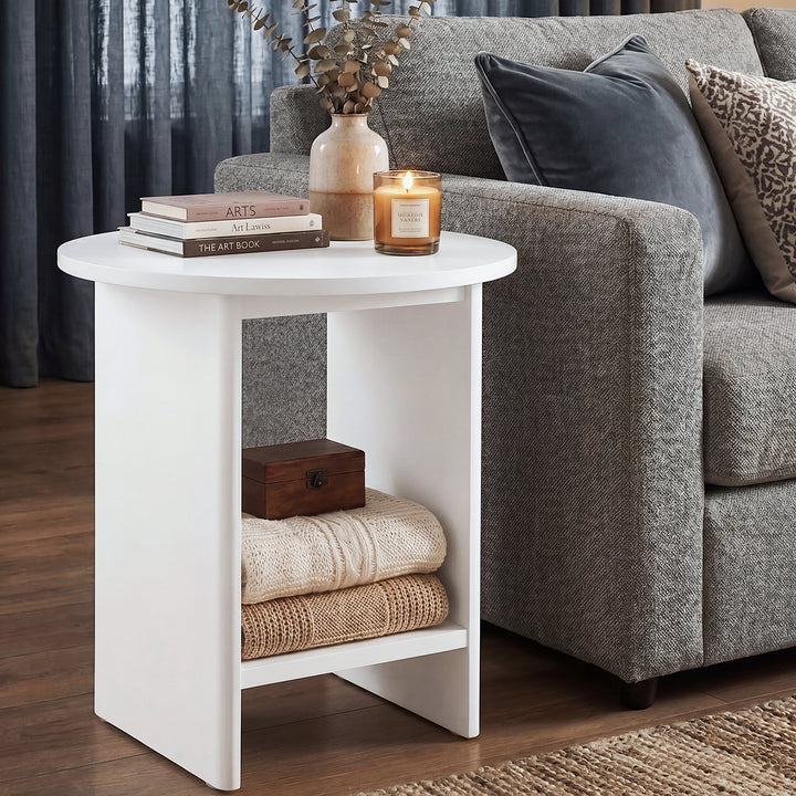 [White] Small Round Side Table with Shelf Living Room beside grey sofa with books and lit candle on top and folded throws stored on lower shelf