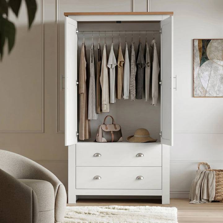 [White] Shaker wardrobe with doors open, showing hanging rail, clothing, handbag, hat, lower drawers, and wall art.