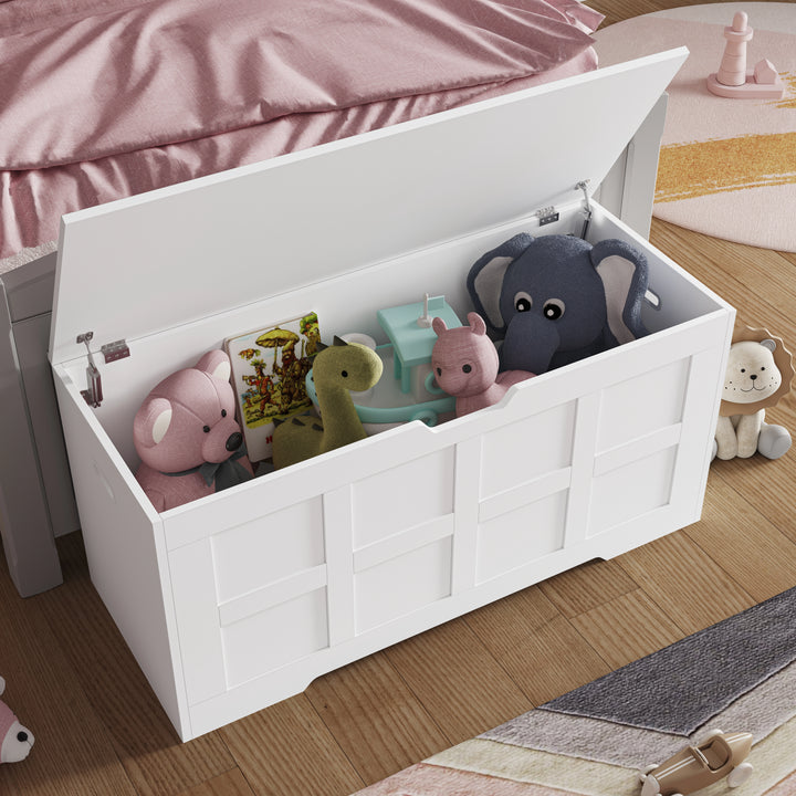 [White] Front view of white shaker storage chest open in a child's room, panel detailing on lid and body, toys visible inside