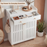 [White] White shoe storage cabinet with top drawer pulled out revealing books, sunglasses and a tray of small items