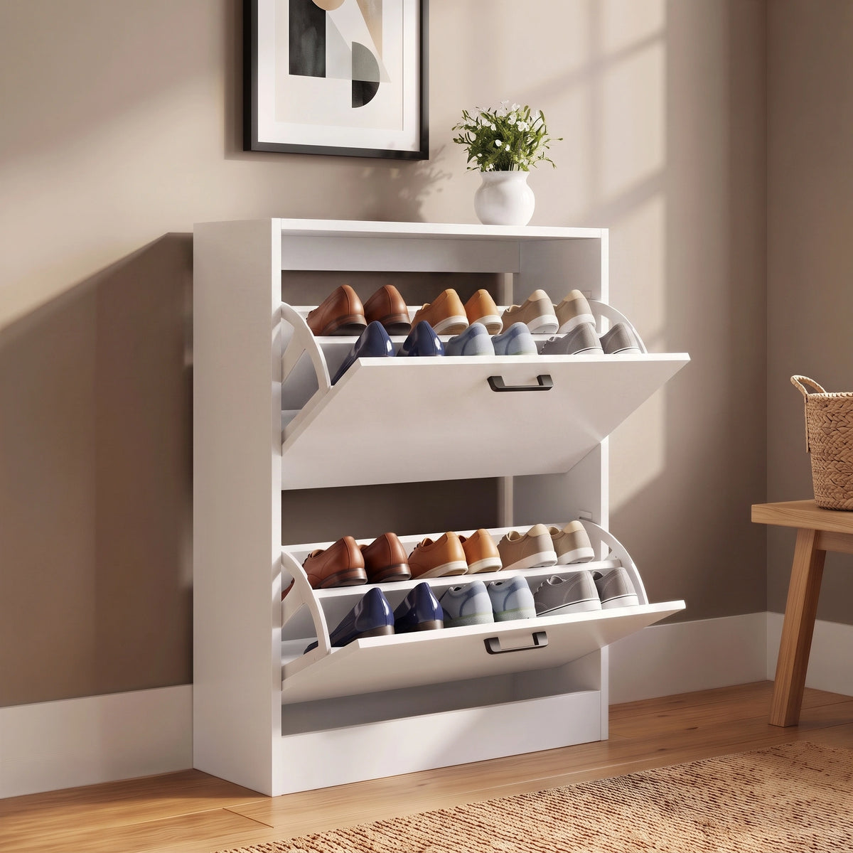 [White] two-tier shoe organizer with pull-out shoe racks, shown in a styled room setting with a beige wall, wooden floor, and a small plant on top.