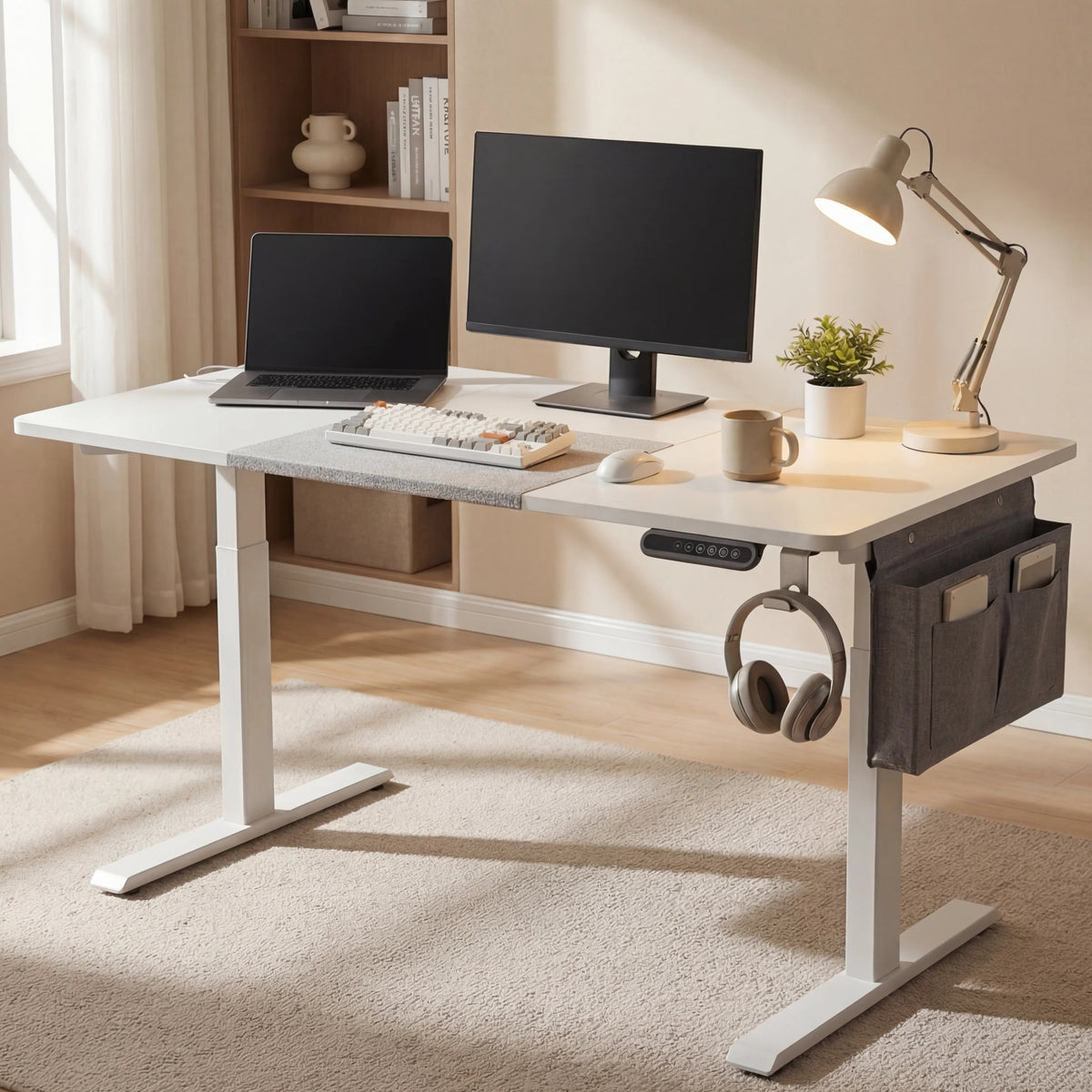 [140cm x 60cm] White electric standing desk 140x60cm in home office with monitor, laptop and bookshelf in background