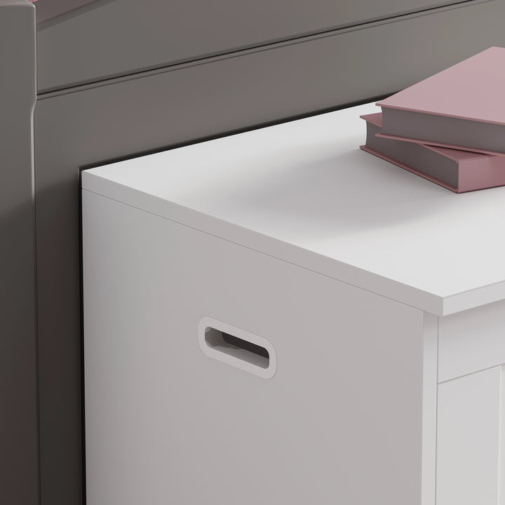 [White] White storage unit with a handle next to a gray cabinet with pink books on top.