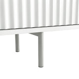 [White] Chrome leg hardware shot on white Flutrina TV unit, fluted door bottom edge visible above leg.