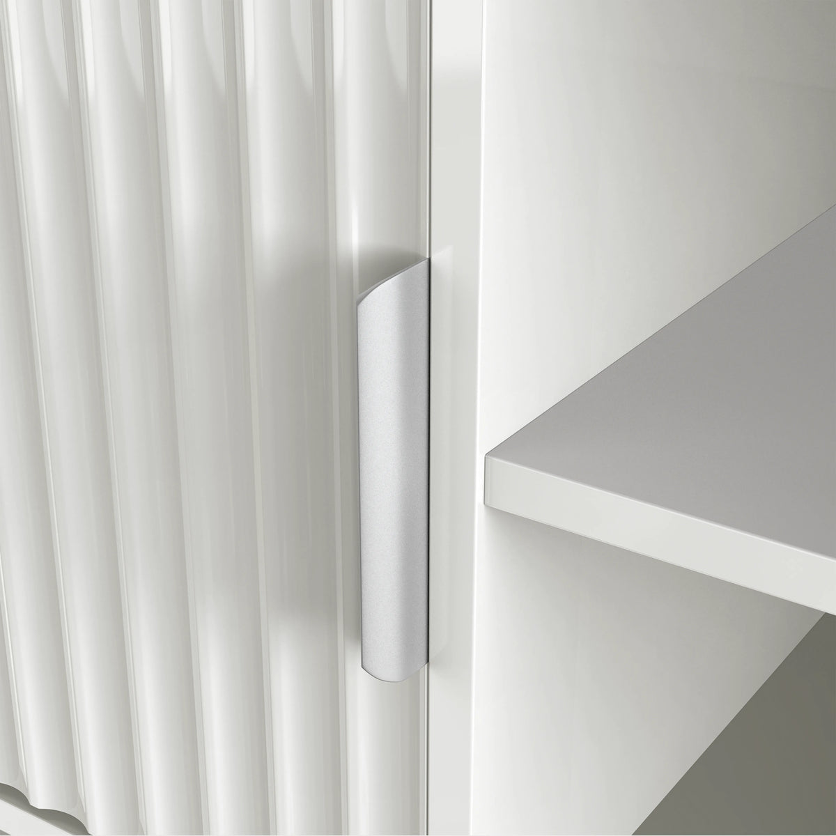 [White] Handle detail on white Flutrina TV unit door, vertical fluted grooves clearly visible across the door surface.