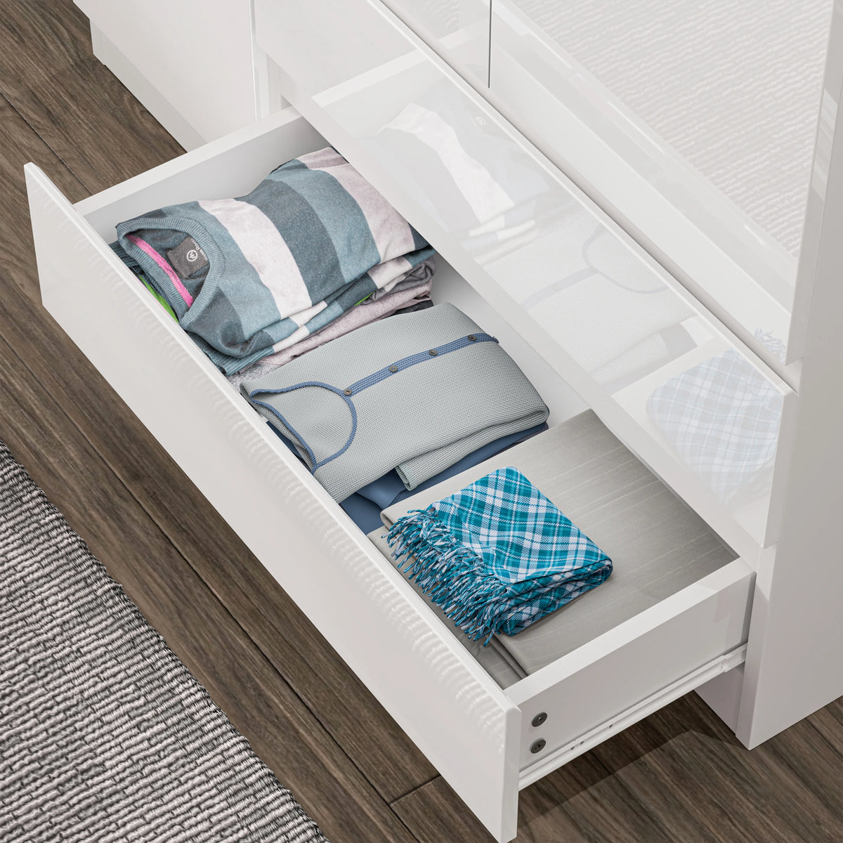[White] Top-down view of pulled-out wardrobe drawer showing organised clothing in white gloss wardrobe