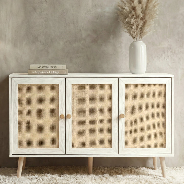 [White] Wovena Rattan 3 Door Sideboard - Adjustable Shelf White straight-on view styled with pampas grass against a concrete wall.