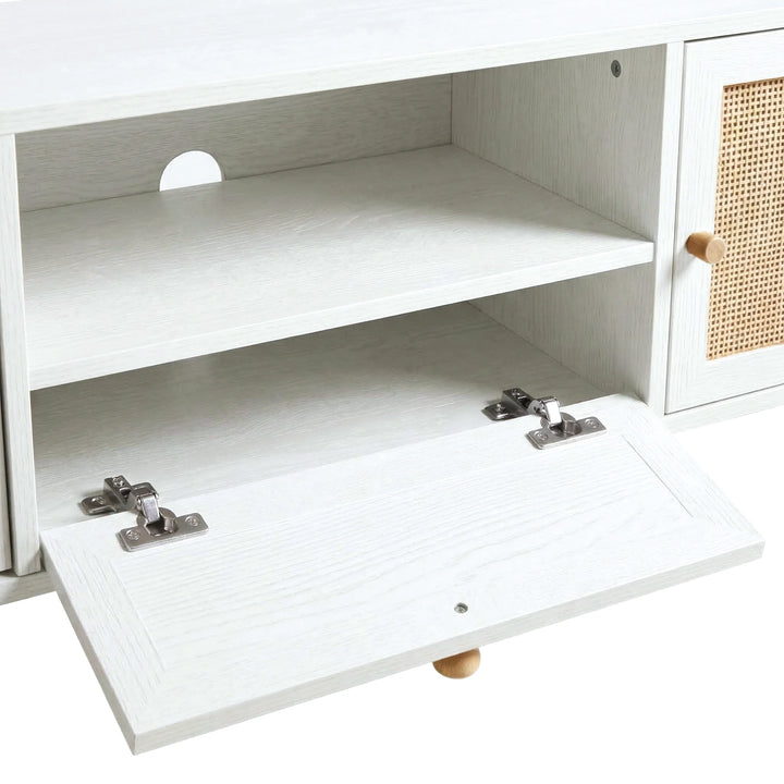 [White] Wovena Rattan TV Unit detail showing centre drop-down drawer with metal hinges, cable management hole, and adjustable shelf inside