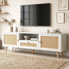 [White] Wovena TV unit angled lifestyle beneath wall-mounted TV with dried pampas, wooden figurine, and stacked books