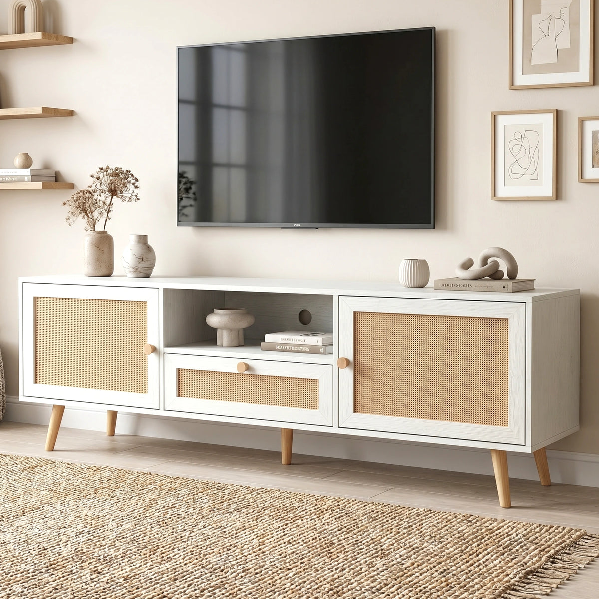 [White] Wovena TV unit angled lifestyle beneath wall-mounted TV with dried pampas, wooden figurine, and stacked books
