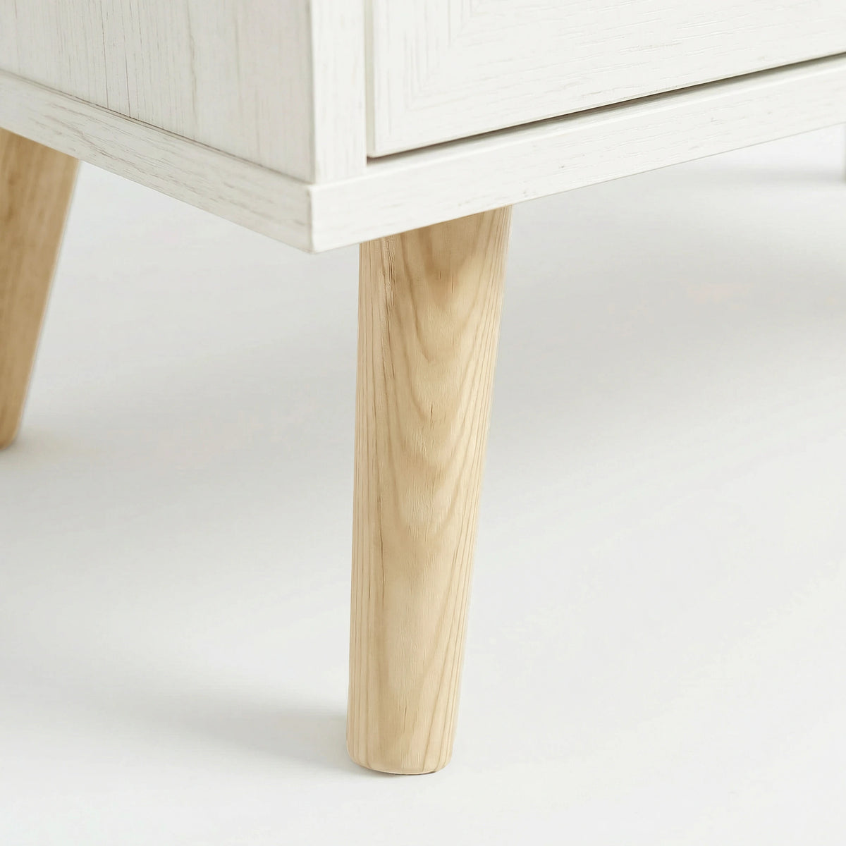 [White] splayed solid pine leg under white melamine wardrobe base with rounded tapering profile