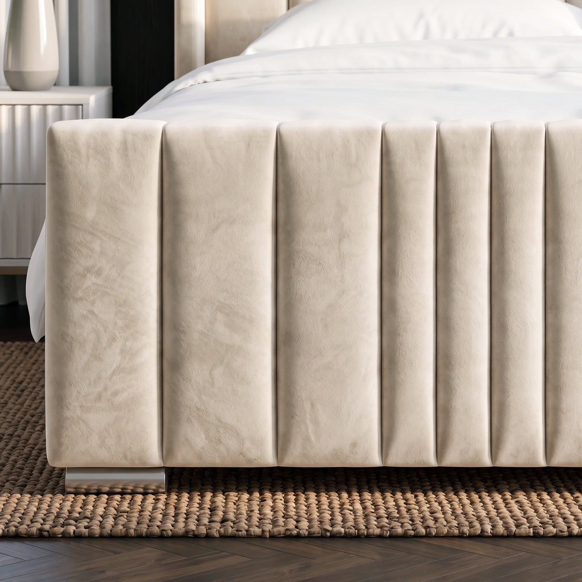 [King | Beige] Close-up of a bed frame upholstered in textured beige fabric with vertical channel tufting, shown in a bedroom setting on a woven rug.